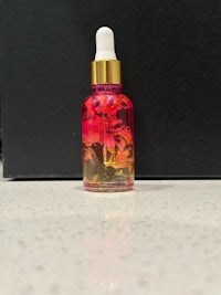 a small bottle of rose oil sitting on a counter