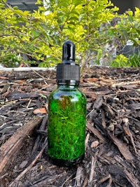 a bottle of essential oil sitting on the ground