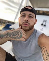 a man with tattoos sitting on a boat