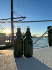 two bottles sitting on a table next to a boat